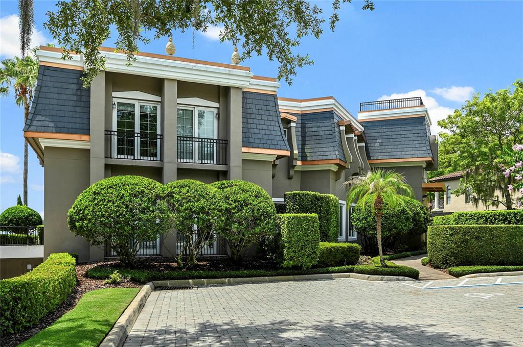 A two-story building with a mansard roof, balconies, and manicured landscaping in front — 660 OSCEOLA AVENUE UNIT 101, WINTER PARK, FL