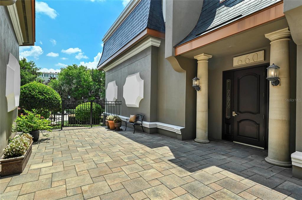 A patio with a metal dining set overlooks a lake with several boat docks — 660 OSCEOLA AVENUE UNIT 101, WINTER PARK, FL