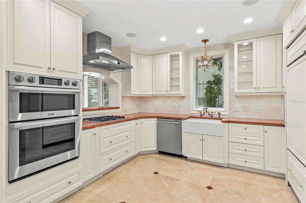 A kitchen with cream cabinets, wood countertops, stainless steel appliances, and a farmhouse sink — 660 OSCEOLA AVENUE UNIT 101, WINTER PARK, FL