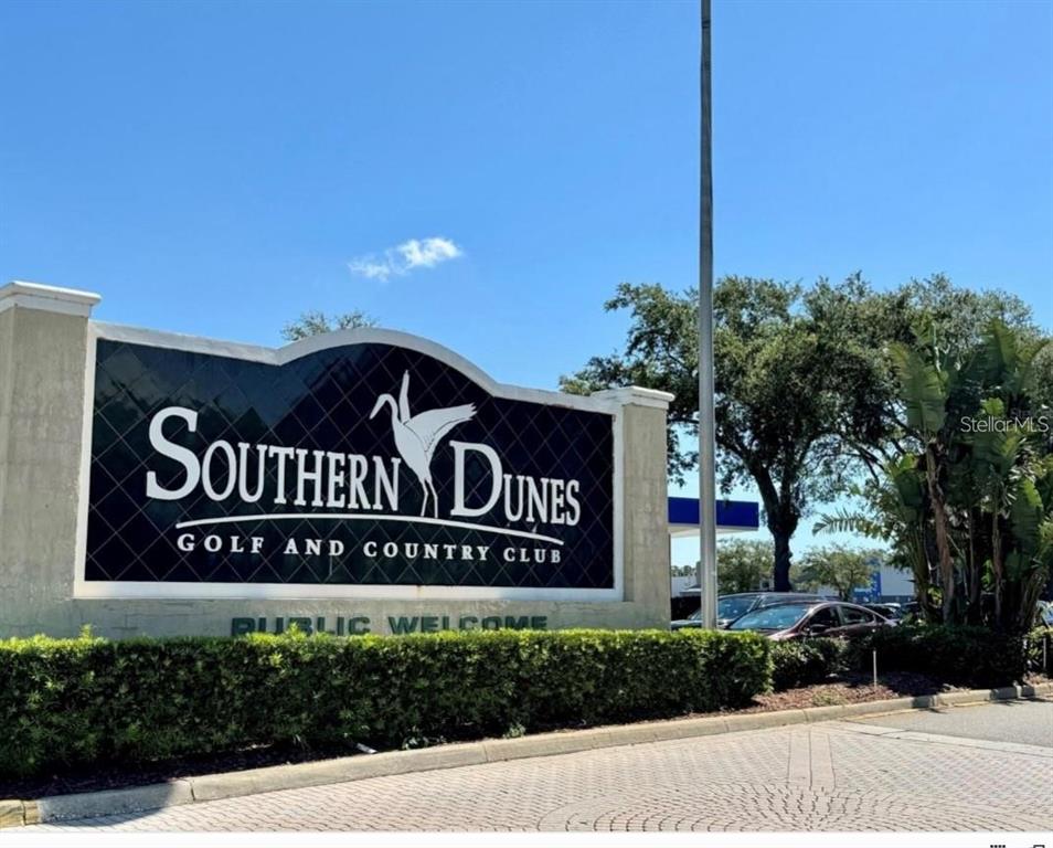 A large sign for Southern Dunes Golf and Country Club stands near a paved road — 1708 CLUBHOUSE COVE, HAINES CITY, FL