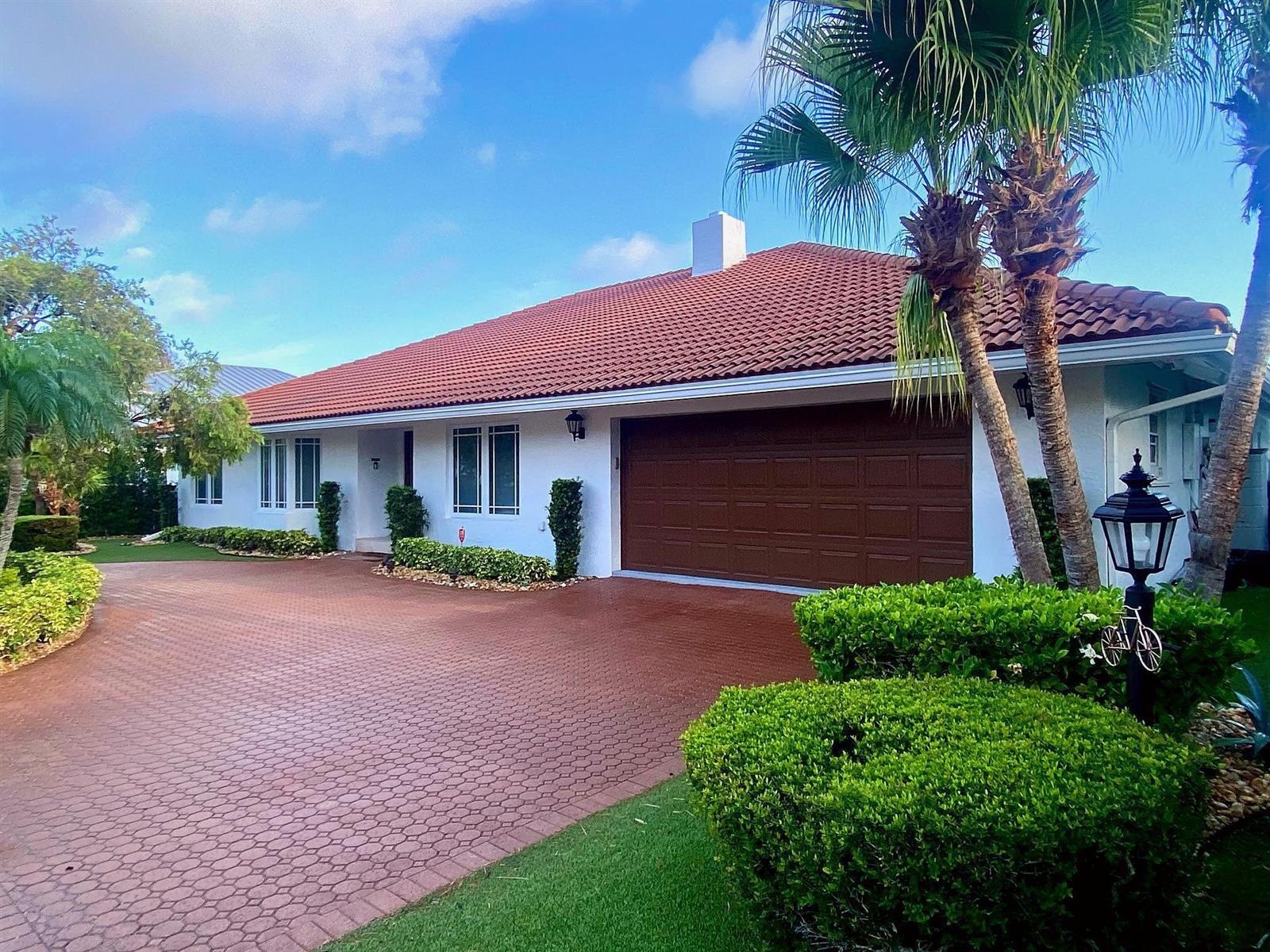 A single-story house with a red tile roof, white walls, and a brown garage door — 885 NE Mulberry Drive, Boca Raton FL 33487, BOCA RATON, FL