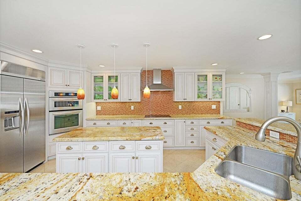 A kitchen with white cabinets, granite countertops, stainless steel appliances, and a tiled backsplash — 885 NE Mulberry Drive, Boca Raton FL 33487, BOCA RATON, FL