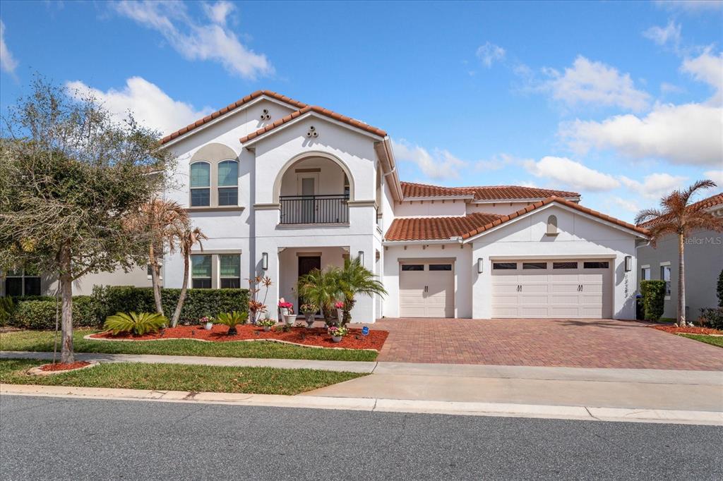 A two-story house with a white stucco exterior, red tile roof, and three-car garage — 13283 ALDERLEY DRIVE, ORLANDO, FL