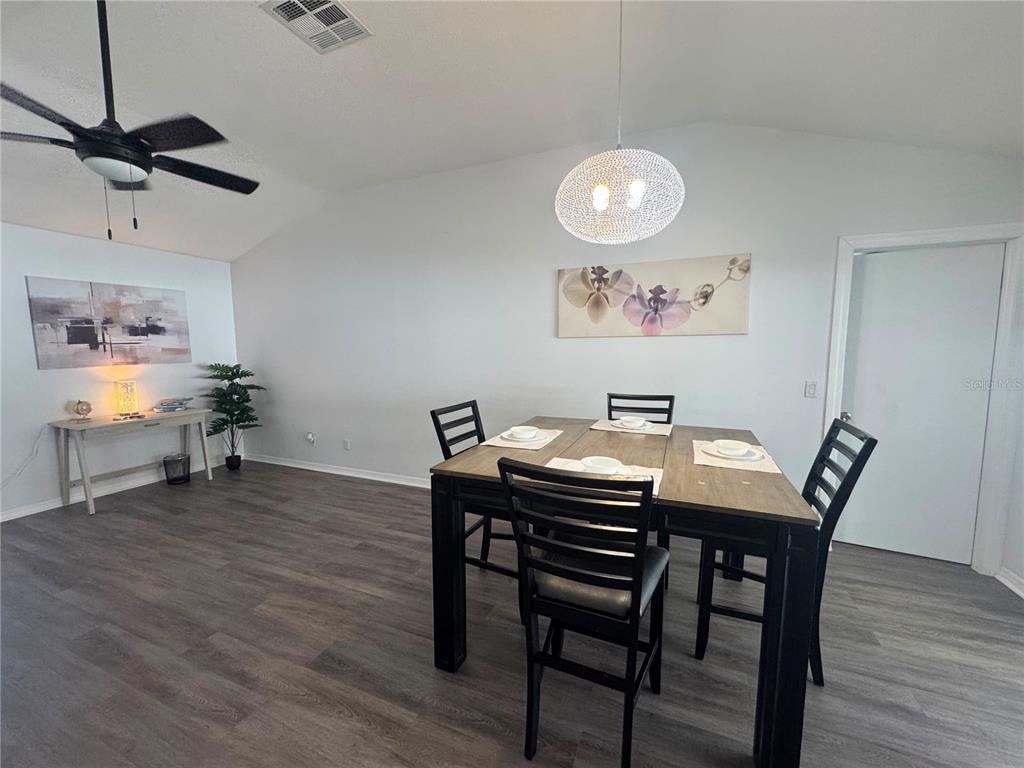 A dining area features a dark wood table, black chairs, and light gray flooring — 12609 130TH STREET, LARGO, FL