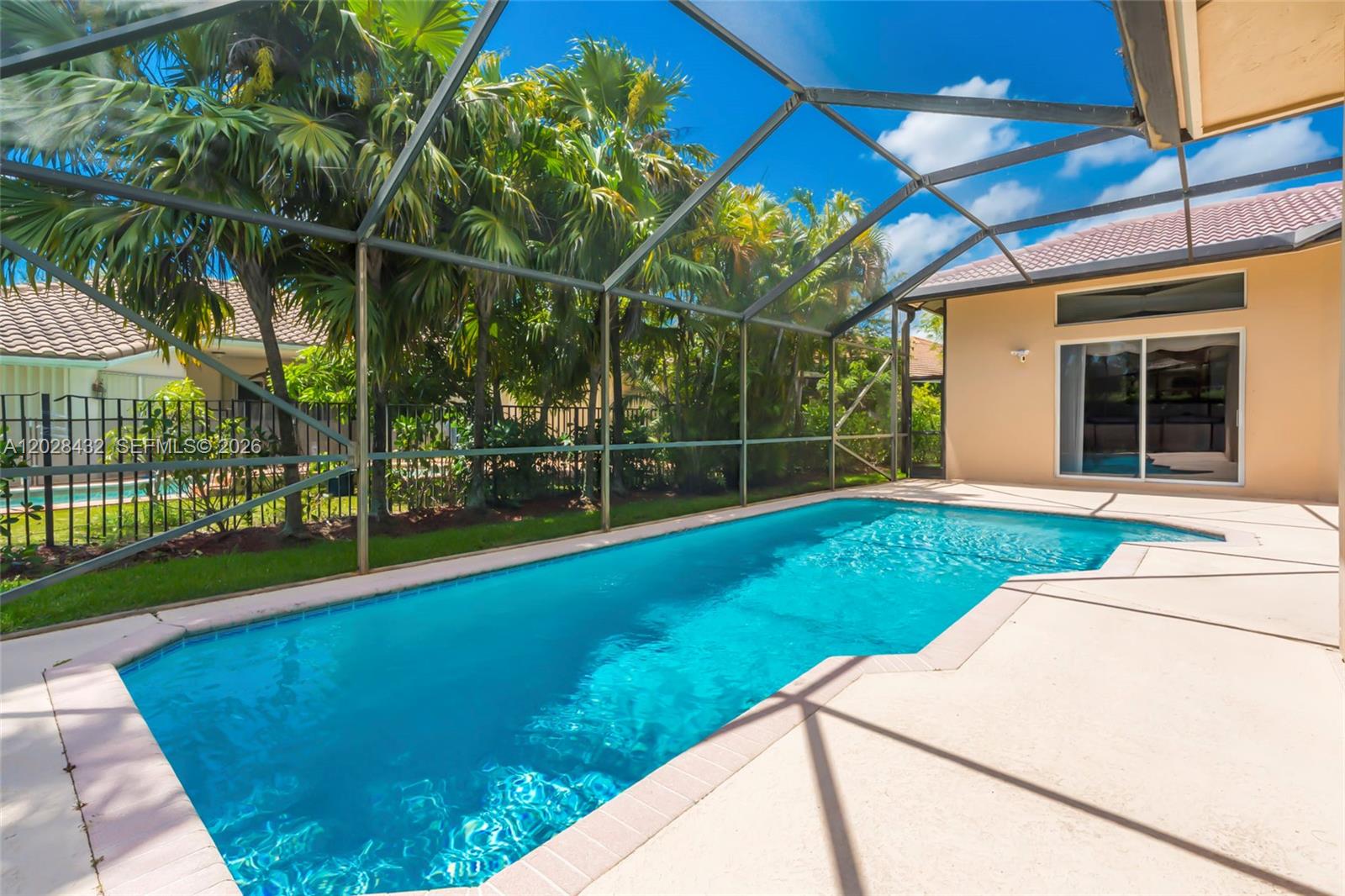 A swimming pool with a screened enclosure sits on a patio next to a house — 3852 Oak Ridge Cir, Weston FL 33331, WESTON, FL