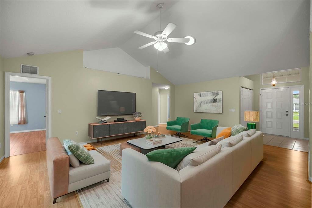A living room features a vaulted ceiling, light green walls, wood flooring, and green armchairs — 6181 SW 84TH PLACE, OCALA, FL