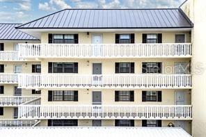 A multi-story apartment building features white balconies and a dark metal roof — 101 N GRANDVIEW STREET UNIT 203, MOUNT DORA, FL