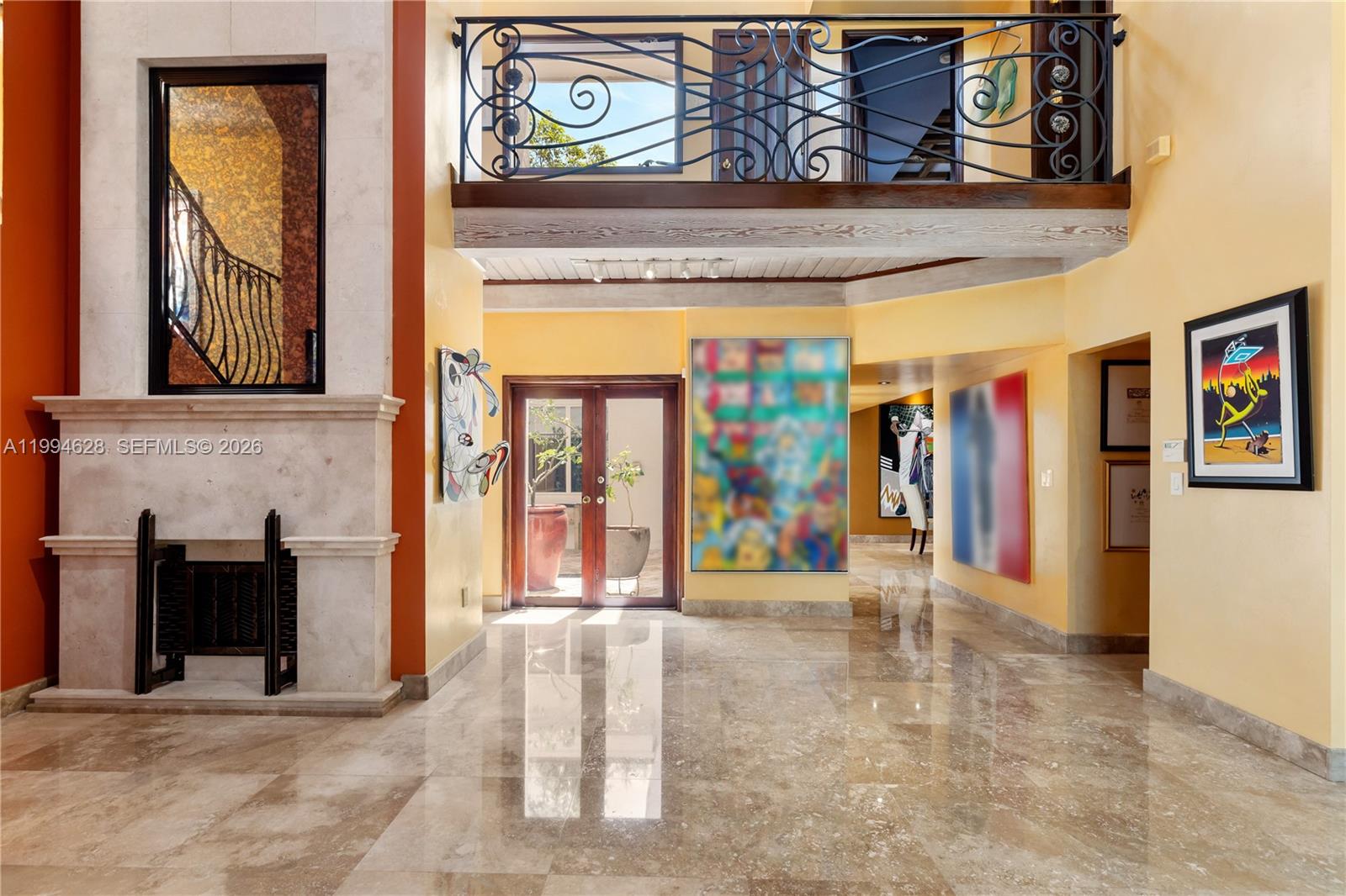A spacious foyer features marble floors, a stone fireplace, and a second-story balcony railing — 20251 W Oak Haven Cir, Miami FL 33179, MIAMI, FL
