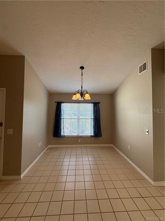 A dining area with beige walls, a tiled floor, and a hanging chandelier — 838 W BOGART COURT, BEVERLY HILLS, FL