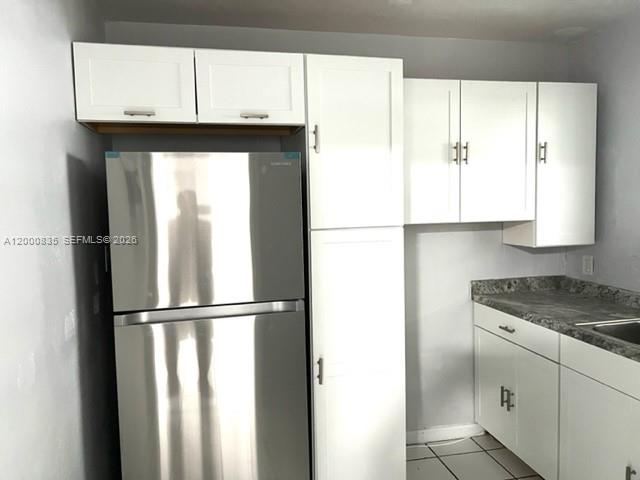 A kitchen features white cabinets, a stainless steel refrigerator, and gray countertops — 504 N 57th Ave, Hollywood FL 33021, HOLLYWOOD, FL