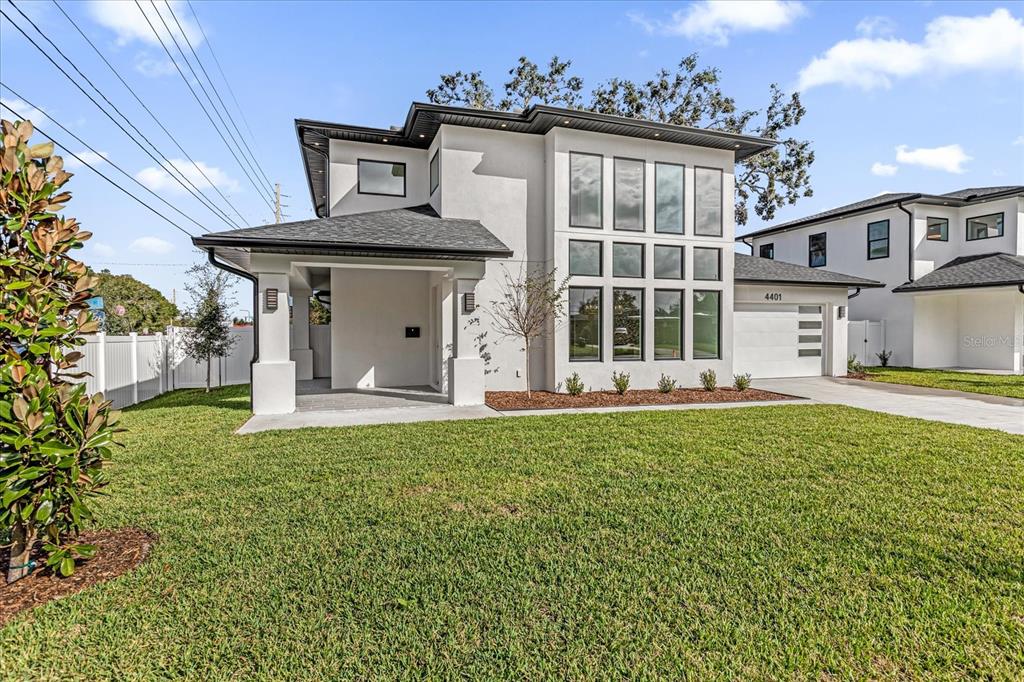 A modern two-story house with white stucco siding, a dark roof, and large vertical windows — 4401 ROCKLEDGE ROAD, ORLANDO, FL