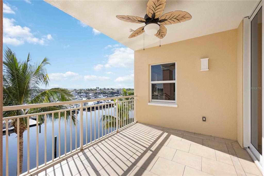 A covered balcony with tile flooring, a ceiling fan, and a view of a marina — 606 RIVIERA DUNES WAY UNIT 302, PALMETTO, FL