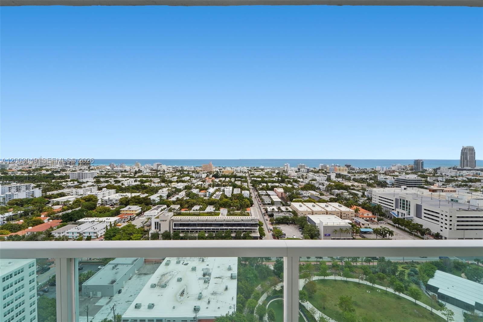 A high-angle view of a city and ocean from a balcony with a glass railing — 650 West Ave # 2612, Miami Beach FL 33139, MIAMI BEACH, FL