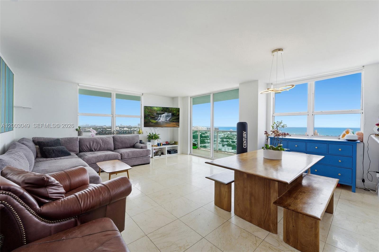 A living and dining area with tile floors, a sectional sofa, and ocean views — 650 West Ave # 2612, Miami Beach FL 33139, MIAMI BEACH, FL