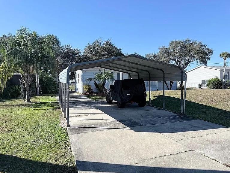 A metal carport covers a concrete driveway leading to a mobile home — 2086 STARBOARD DRIVE, GENEVA, FL
