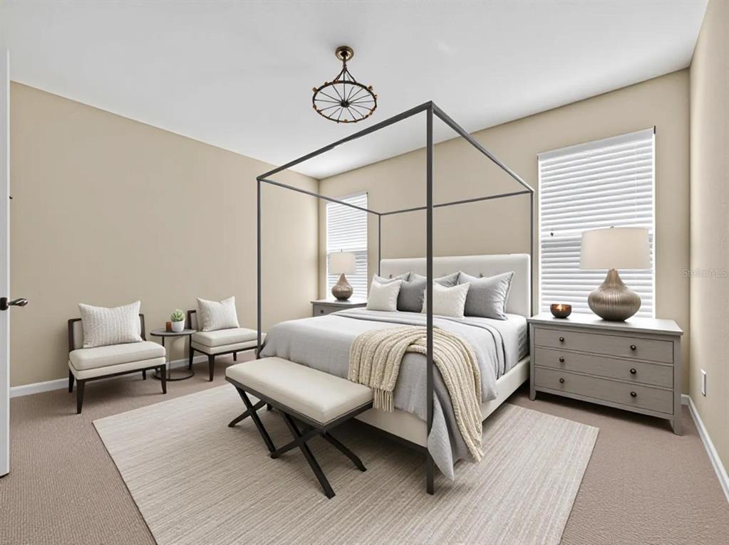 A bedroom features a bed, two black dressers, two armchairs, and a ceiling fan — 8915 DELLA SCALA CIRCLE, ORLANDO, FL
