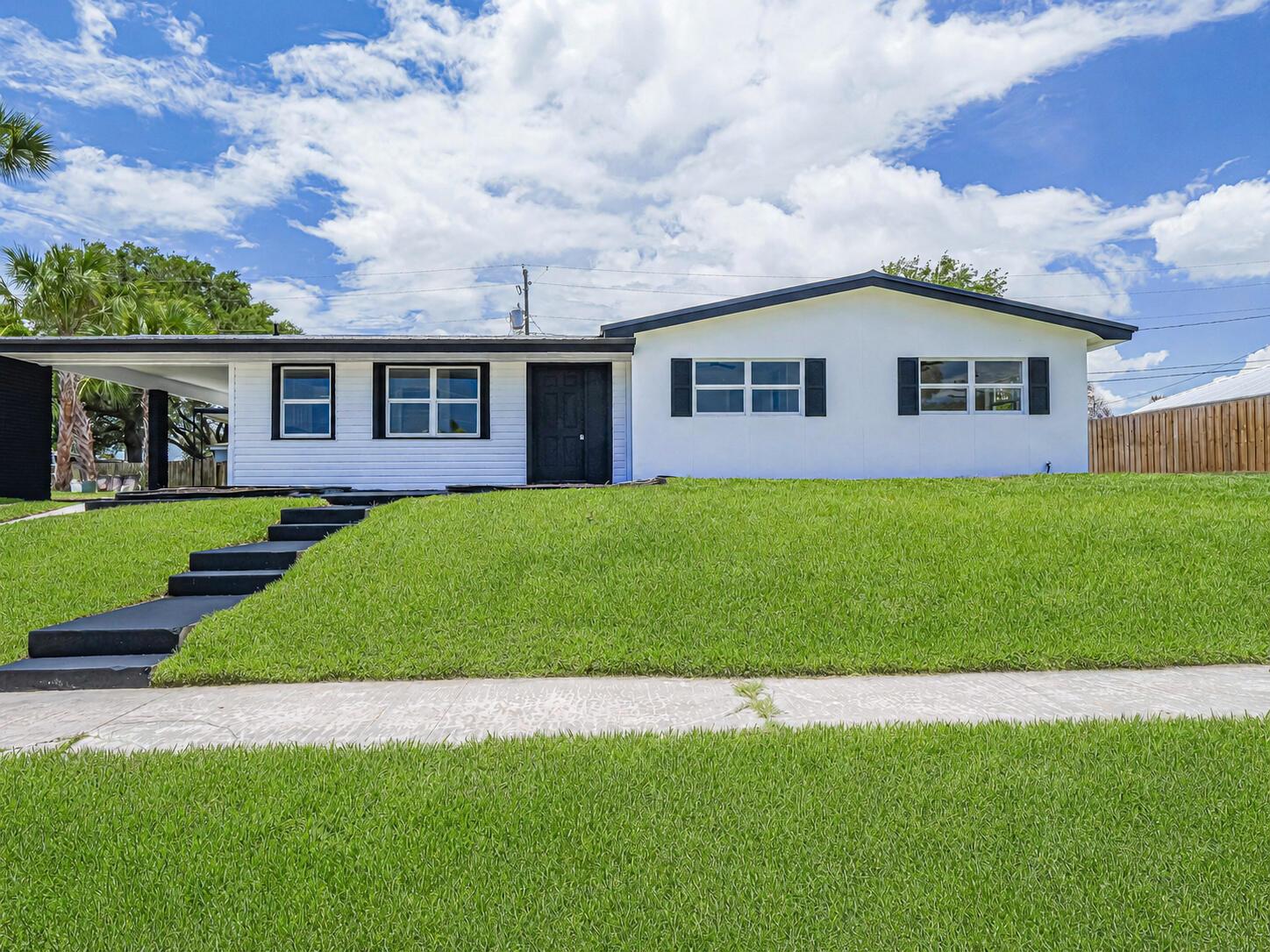 A white single-story house with a black front door, black shutters, and a front lawn — 375 Manly Avenue, Sebastian FL 32958, SEBASTIAN, FL