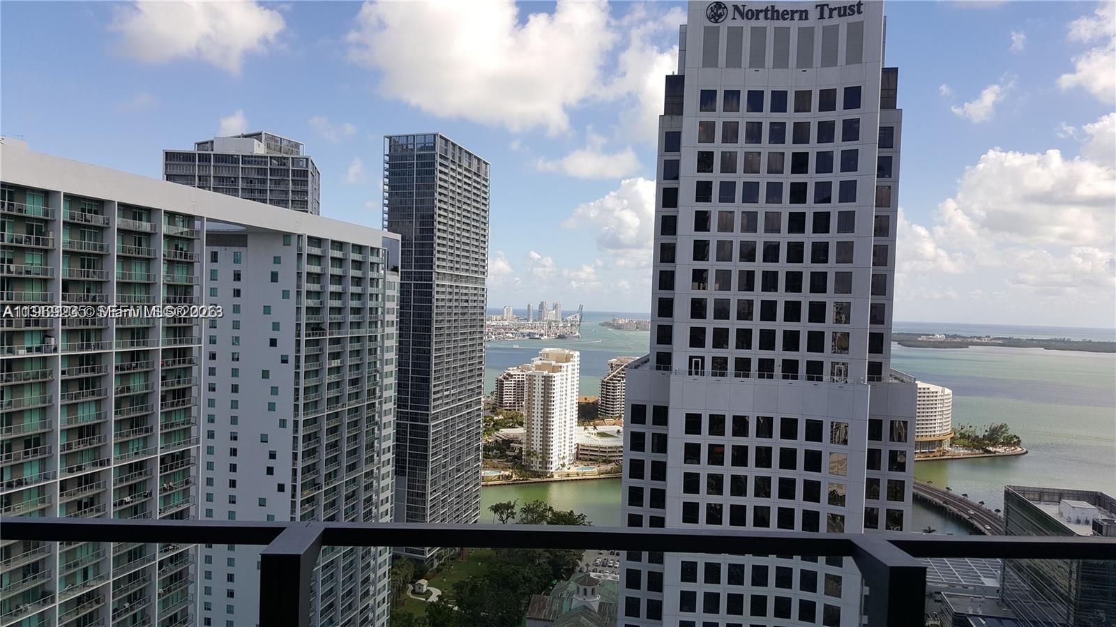 A high-angle view shows several modern skyscrapers and a body of water in Miami — 68 SE 6th St # 3305, Miami FL 33131, MIAMI, FL