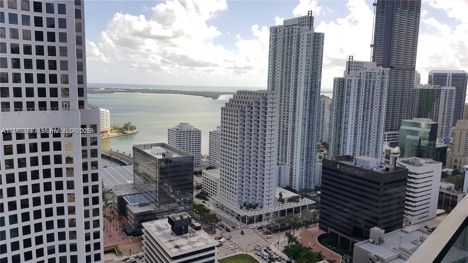An elevated view of a dense urban skyline featuring multiple high-rise buildings near the water — 68 SE 6th St # 3305, Miami FL 33131, MIAMI, FL