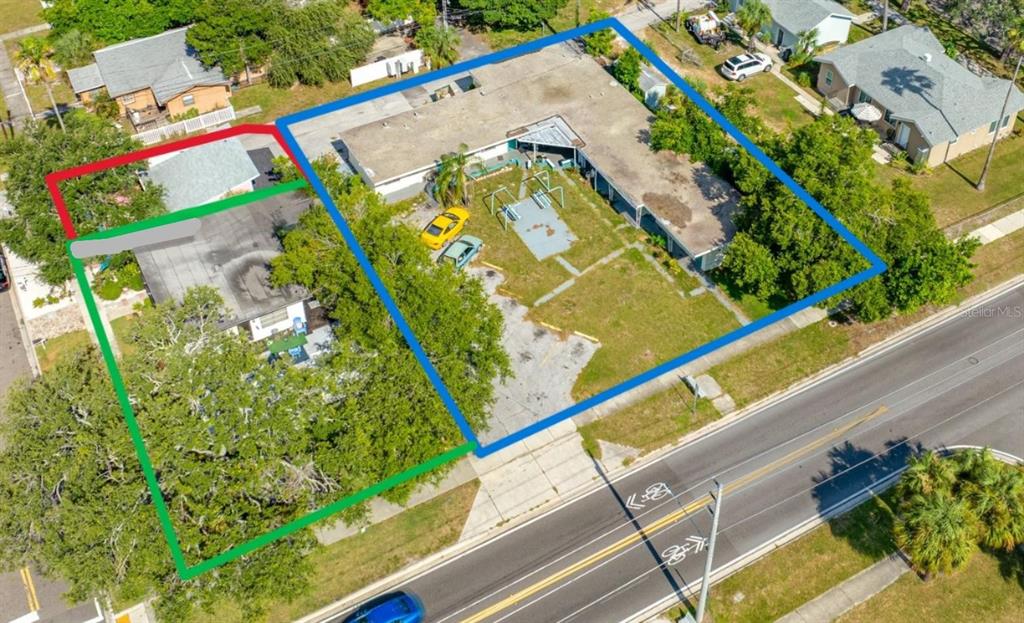 An aerial view shows two adjacent properties with buildings, parking areas, and trees near a road — 1762 N FORT HARRISON AVENUE, CLEARWATER, FL