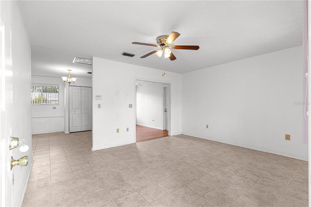 An interior view of a room with tiled floors, a ceiling fan, and white walls — 8208 SW 108TH LANE ROAD, OCALA, FL