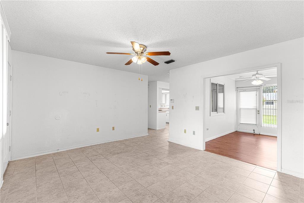 A living room with light tile flooring, white walls, and a ceiling fan — 8208 SW 108TH LANE ROAD, OCALA, FL