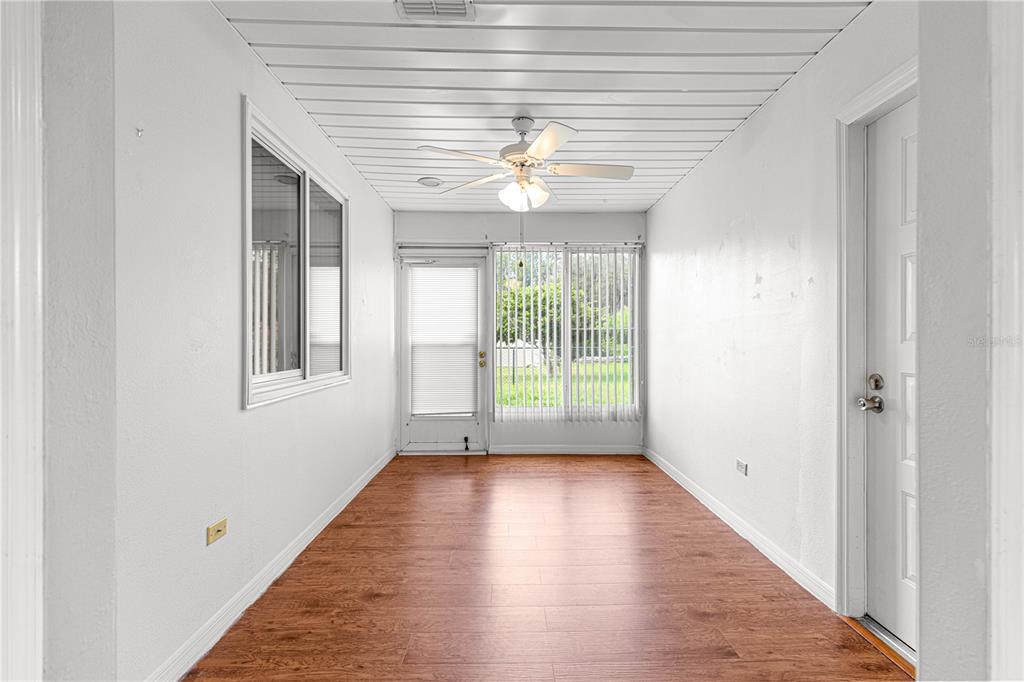 A sunroom with white walls, a wood-look floor, and a ceiling fan — 8208 SW 108TH LANE ROAD, OCALA, FL