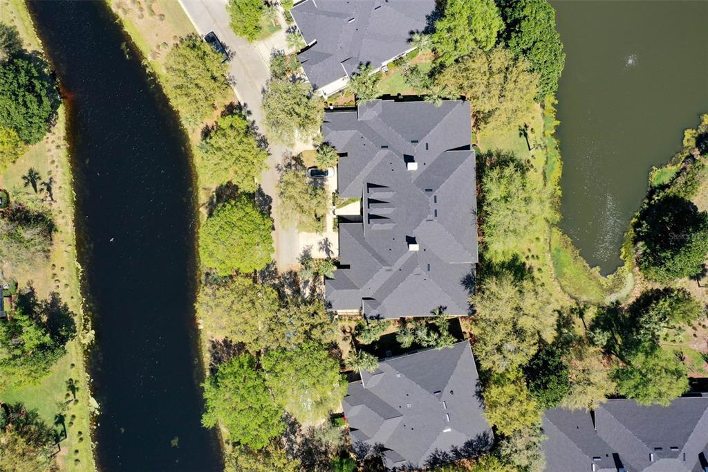 An aerial view shows a residential building with a dark roof nestled between two ponds — 10 RIVER POINT DRIVE, PALM COAST, FL