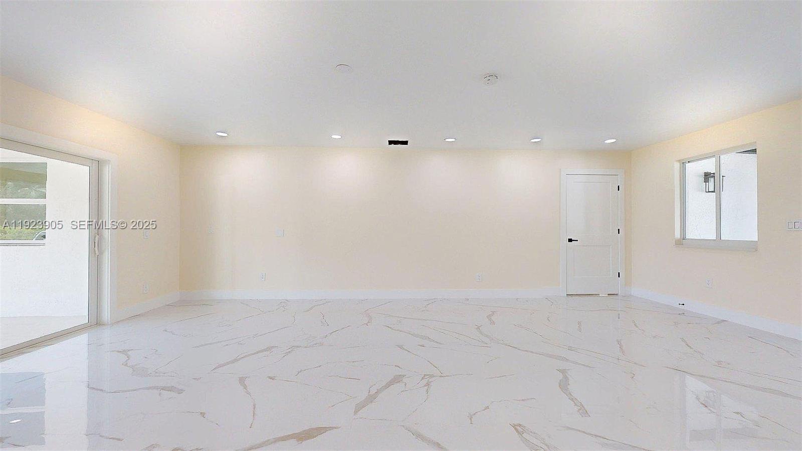 An empty room features light-colored walls, recessed lighting, a white door, and marble-patterned tile flooring — 3801 SW 132nd Ave, Miami FL 33175, MIAMI, FL
