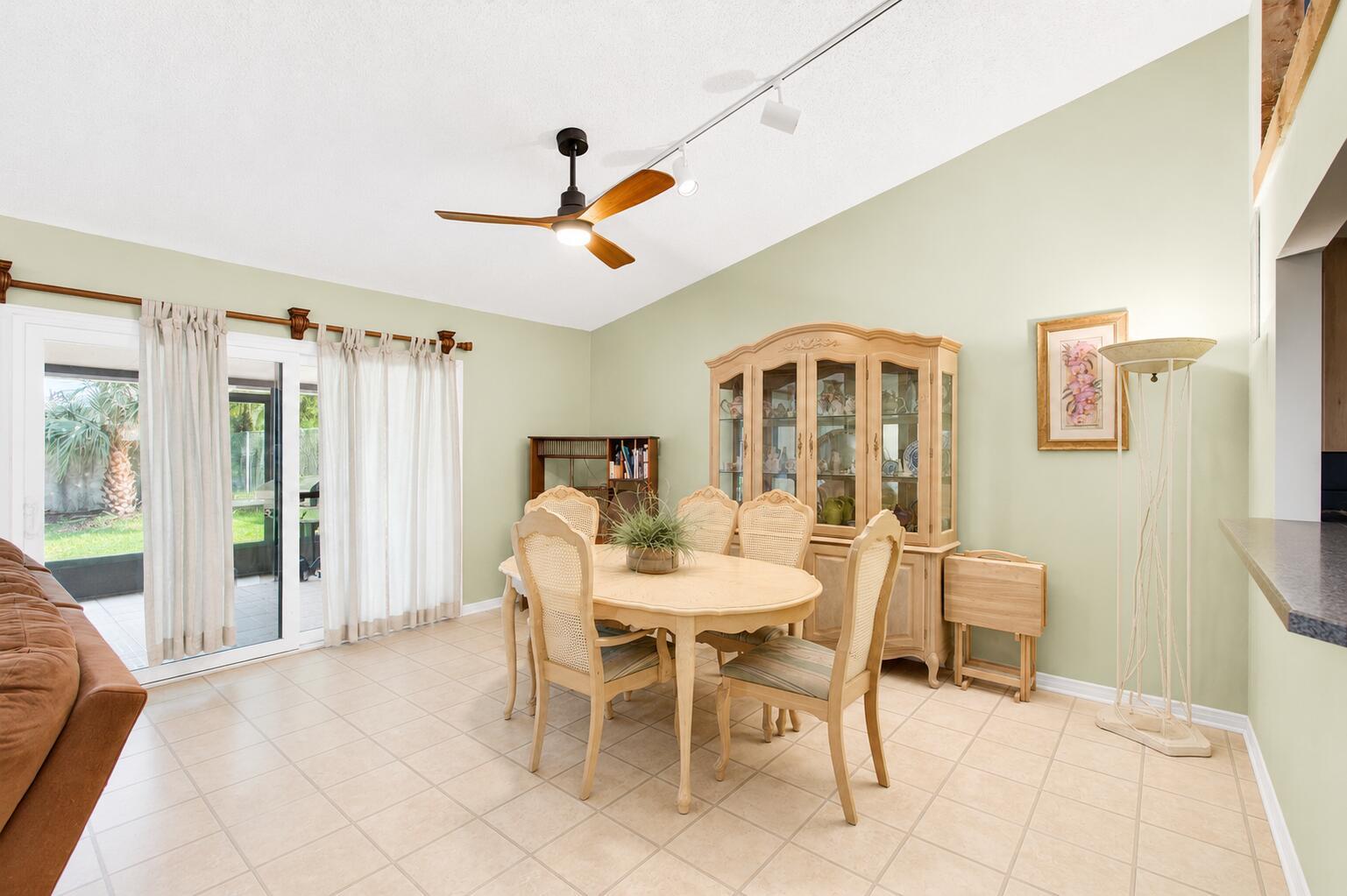 A dining room with light green walls, tile flooring, a wooden hutch, and sliding doors — 2400 SW 19th Avenue, Boynton Beach FL 33426, BOYNTON BEACH, FL