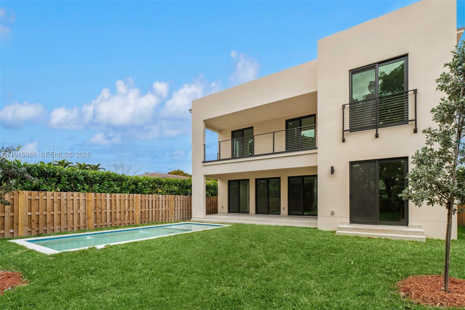 A modern two-story house with a rectangular swimming pool and a wooden fence in the backyard — 1366 SW 15th St, Miami FL 33145, MIAMI, FL