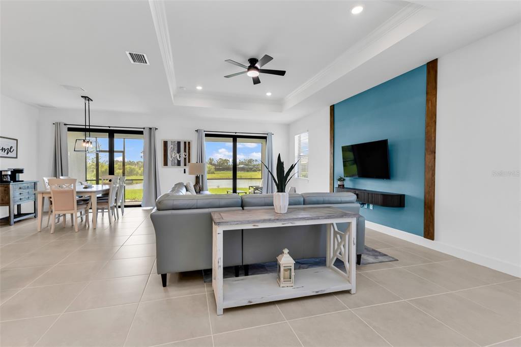 An entryway features a blue accent wall, a floating wooden shelf, and a patterned rug — 4400 LAKESIDE GROVE PLACE, NORTH PORT, FL