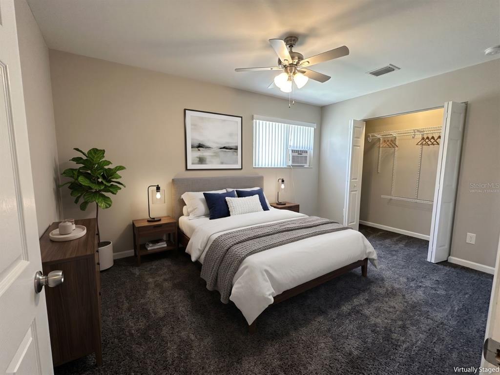 A bedroom with a bed, nightstands, a dresser, a plant, and an open closet — 5568 GREEN SHADOWS PLACE UNIT 21-1, ORLANDO, FL