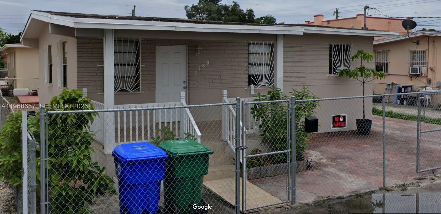 A single-story house with a fenced front yard, white railings, and two large trash bins — 1781 NW 19th St, Miami FL 33125, MIAMI, FL