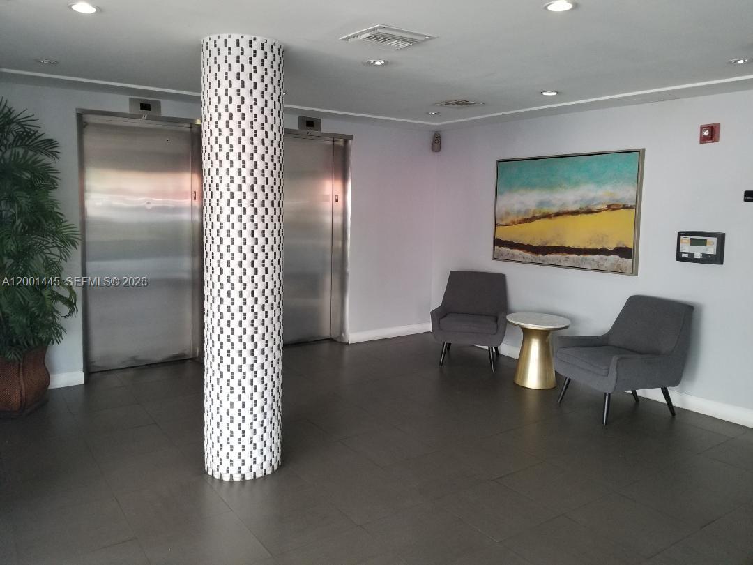 A lobby features two elevator doors, a patterned column, and two gray chairs with a table — 1300 Lincoln Rd # A301, Miami Beach FL 33139, MIAMI BEACH, FL