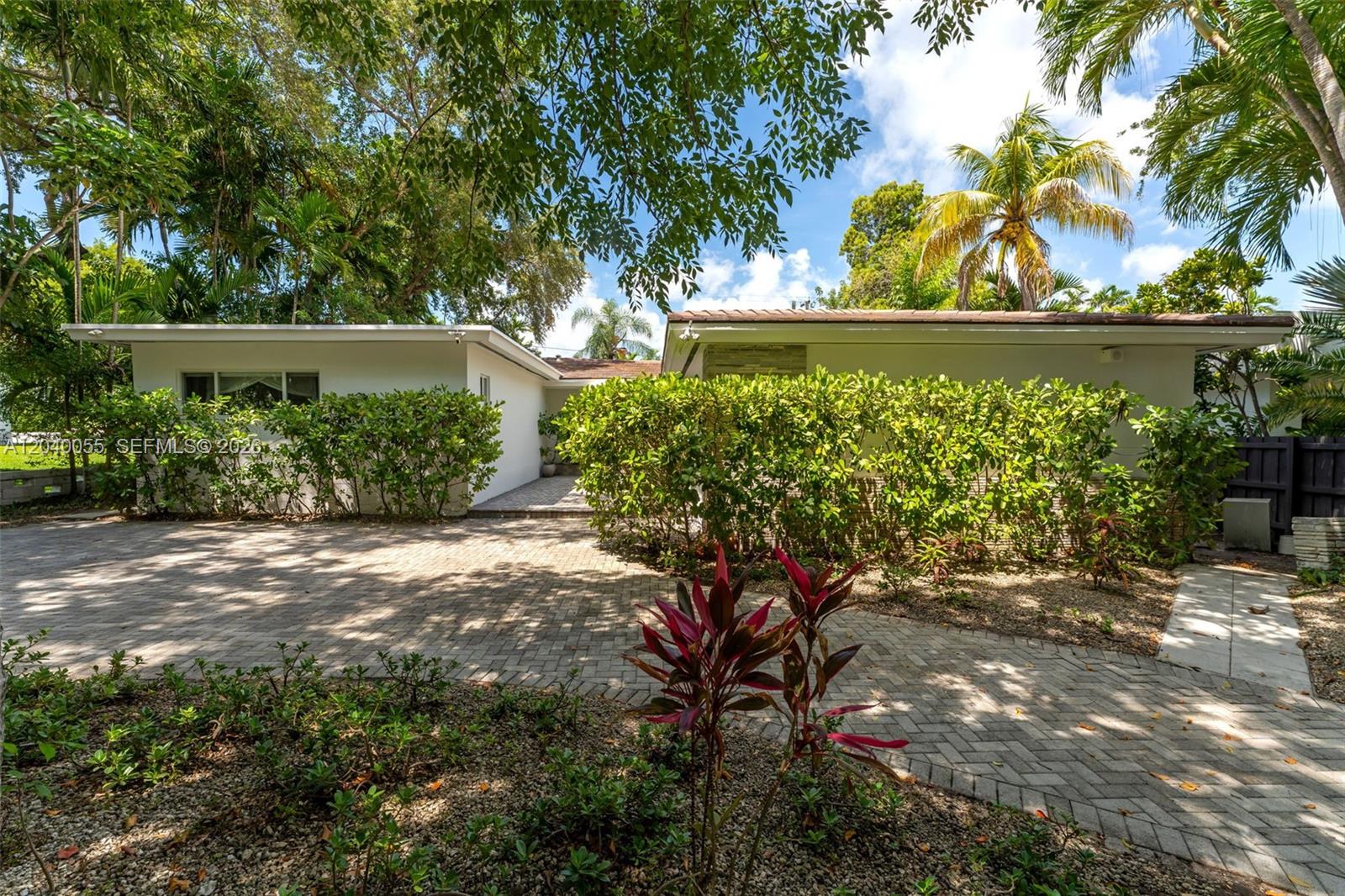 A paved courtyard leads to a front entrance with a curved overhang and steps — 8 Pinta Rd, Miami FL 33133, MIAMI, FL