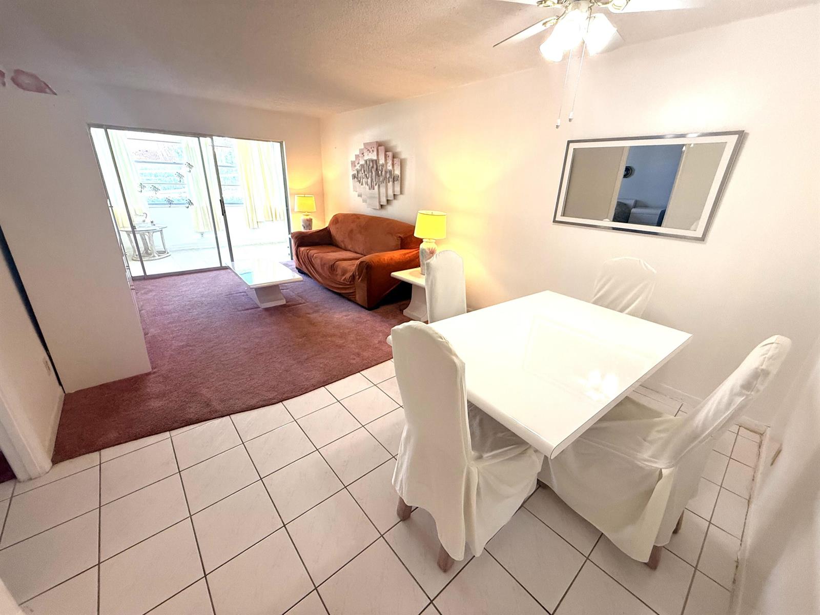 A living and dining area features white tile floors, a brown sofa, and a dining set — 3050 Holiday Springs Boulevard # 111, Margate FL 33063, MARGATE, FL