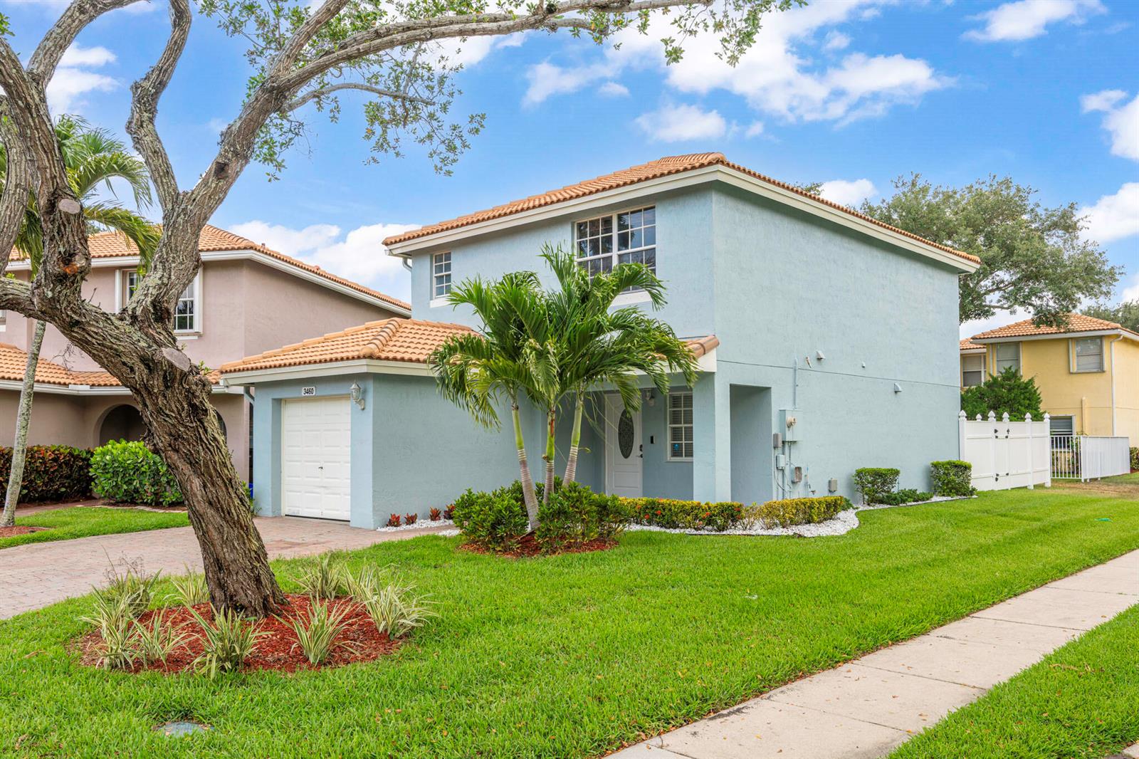 A two-story light blue house with a tile roof and a single-car garage — 3460 Commodore Court, West Palm Beach FL 33411, WEST PALM BEACH, FL