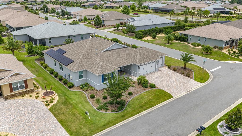 An aerial view of a suburban house with a paved driveway and solar panels — 8418 SW 93RD CIRCLE, OCALA, FL