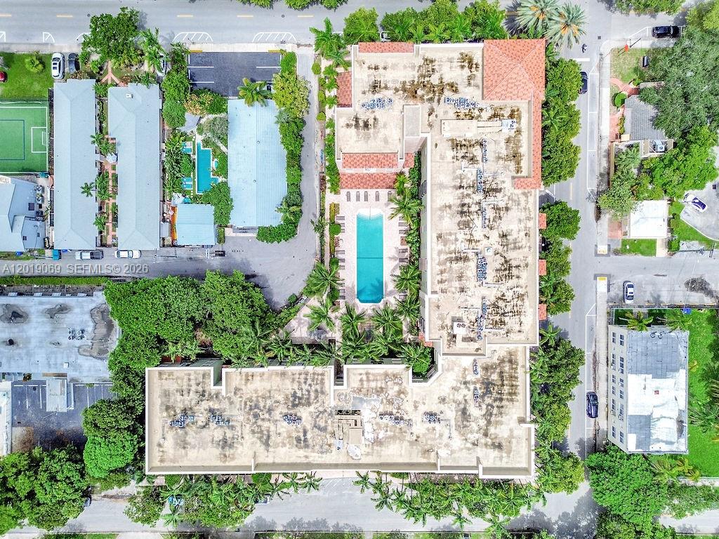 An aerial view shows a multi-story apartment building with a central pool and surrounding landscaping — 1900 Van Buren St # 113B, Hollywood FL 33020, HOLLYWOOD, FL