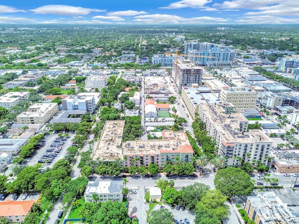 An aerial view shows a multi-story apartment complex surrounded by trees and urban development — 1900 Van Buren St # 113B, Hollywood FL 33020, HOLLYWOOD, FL