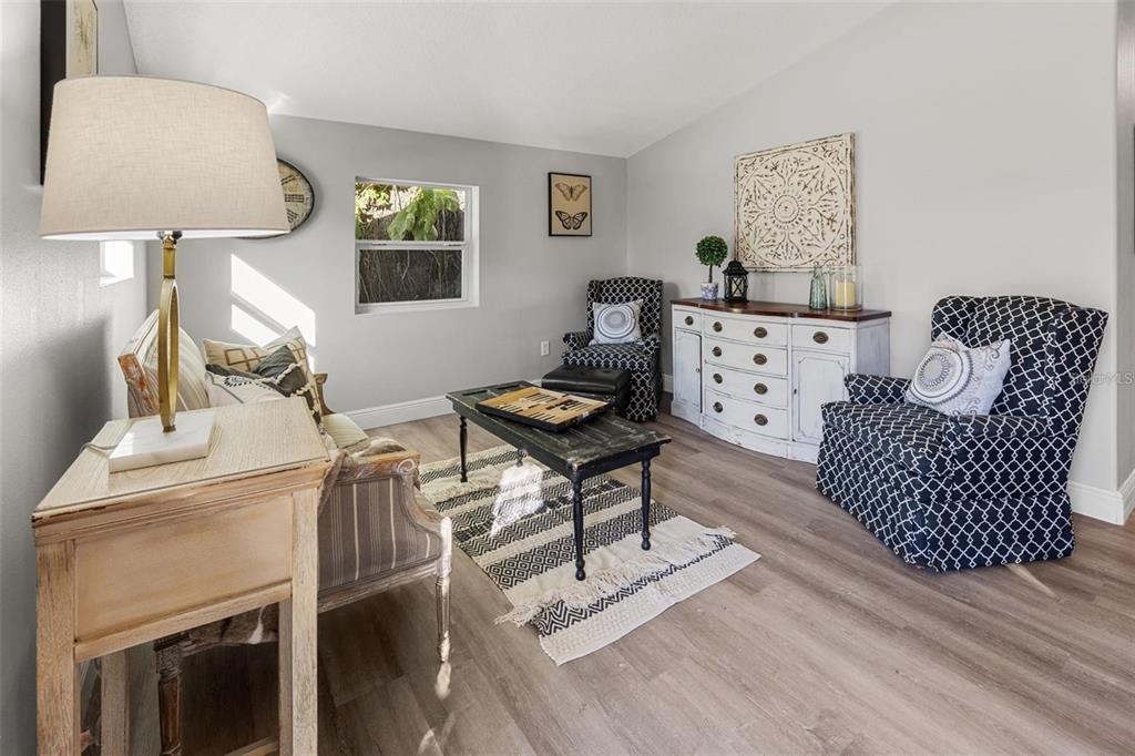 A living room features a patterned armchair, a wooden console, and a central coffee table — 1606 E OSBORNE AVENUE, TAMPA, FL