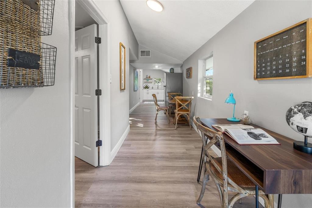 A hallway leads to a kitchen area, featuring a desk with a globe and calendar — 1606 E OSBORNE AVENUE, TAMPA, FL