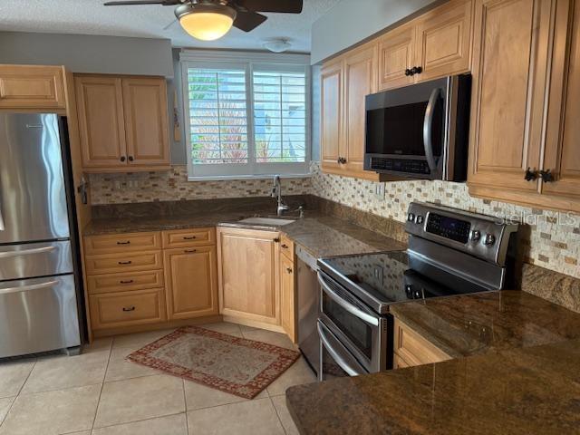 A kitchen features light wood cabinets, stainless steel appliances, and a brown granite countertop — 737 BAYPORT WAY UNIT D, LONGBOAT KEY, FL