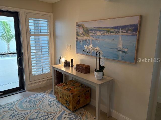 A console table with a decorative chest and artwork sits in a bright entryway — 737 BAYPORT WAY UNIT D, LONGBOAT KEY, FL
