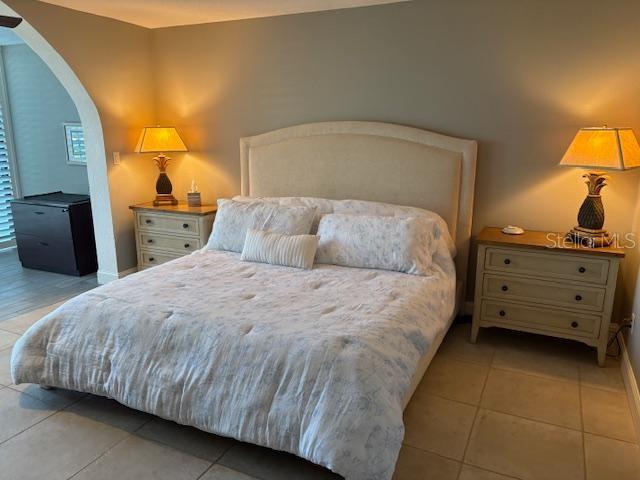 A bedroom features a bed with a tufted headboard, two nightstands, and matching lamps — 737 BAYPORT WAY UNIT D, LONGBOAT KEY, FL