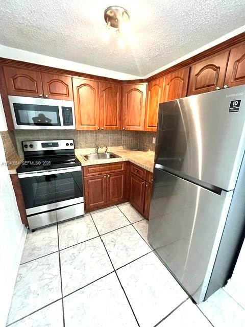 A kitchen features wood cabinets, stainless steel appliances, and light-colored tiled flooring — 444 SW 4th St # 404, Miami FL 33130, MIAMI, FL