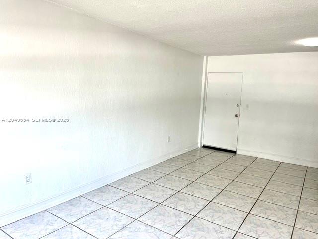 An empty room features white walls, a white door, and light-colored tiled flooring — 444 SW 4th St # 404, Miami FL 33130, MIAMI, FL