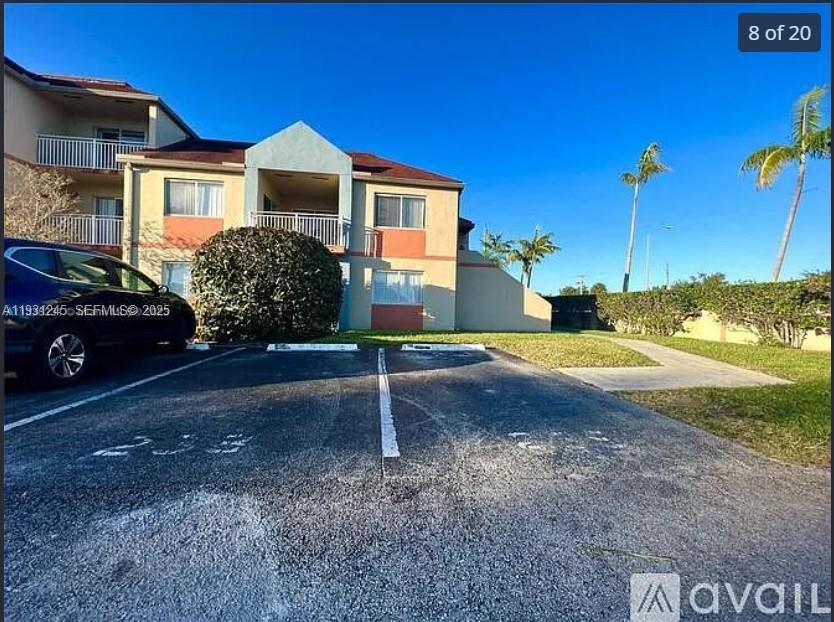 A multi-story apartment building exterior features a parking lot with marked spaces in front — 18810 NW 57th Ave # 102, Hialeah FL 33015, HIALEAH, FL