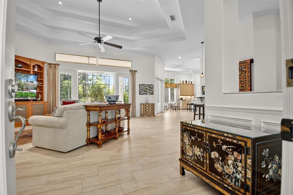 A view from a doorway into a spacious living room with tile floors and tray ceilings — 10 S WATERVIEW DRIVE, PALM COAST, FL
